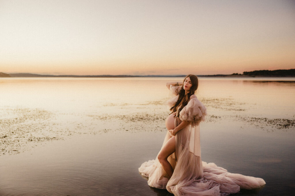 Twilight portrait of pregnant woman at the lake. 