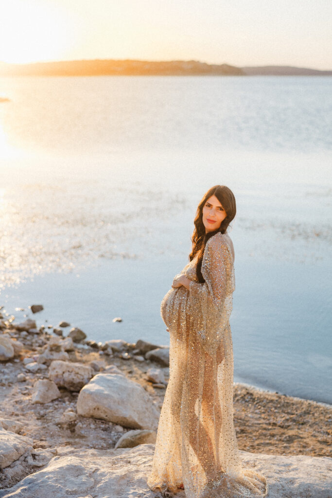 Mom to be with sparkly dress at sunset. 