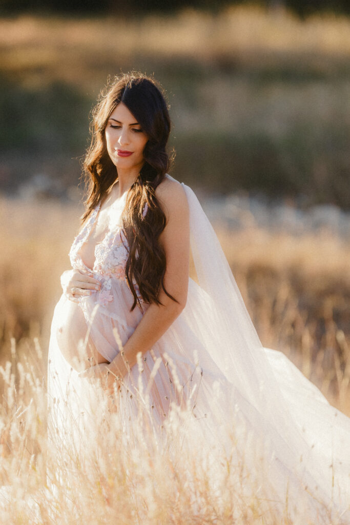 Close up of pregnant mom to be in a field. 